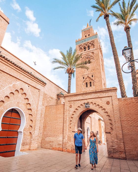 A couple walks in front of the Koutoubia Mosque in Marrakech