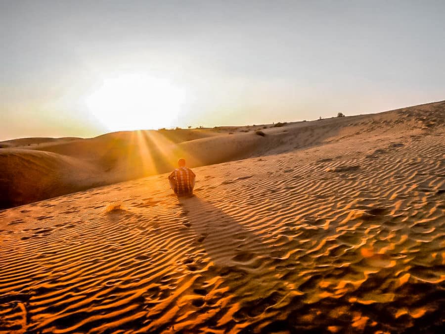 A solo traveller sitting in the desert