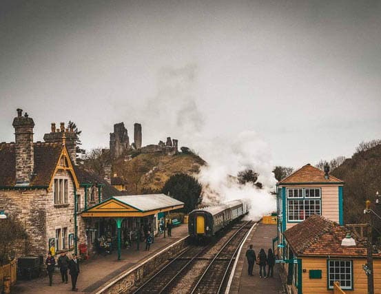 A view of the train station and castle on a hill in Corfe Castle, Dorset