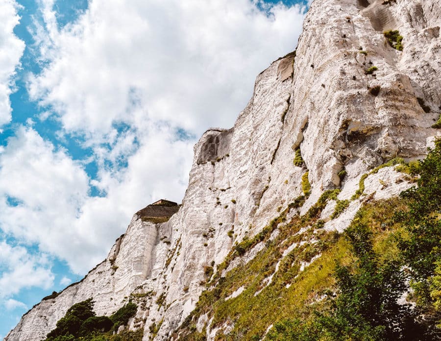 A view looking up at the White Cliffs of Dover from below