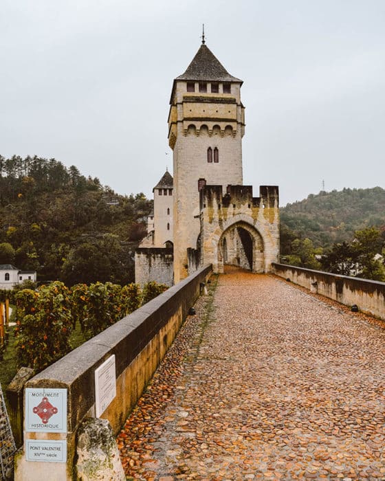 Walking across the medieval bridge, Pont Valentré in Cahors, France